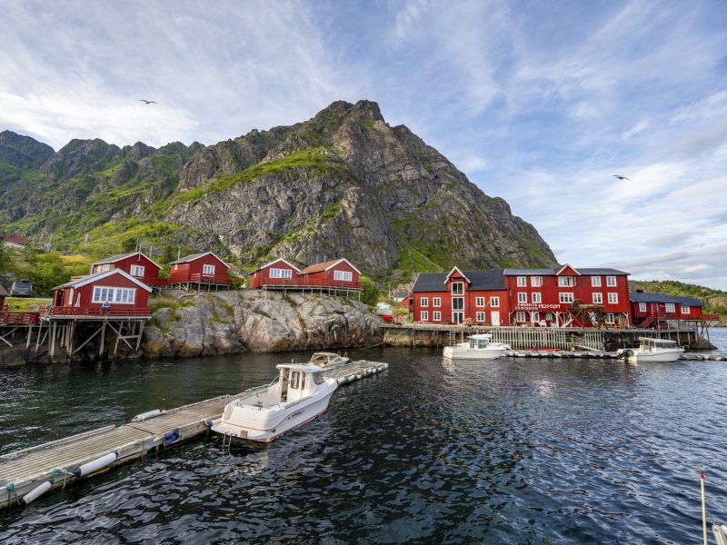 Traditional red rorbuer wooden cabins with stockfish museum, on stilts on the shore, fishing village Å i Lofoten, Lofoten, Nordland, Norway