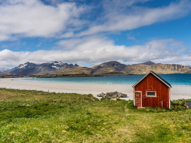 Golden sand and azure sea of Ramberg Beach, Lofoten Islands, Norway with